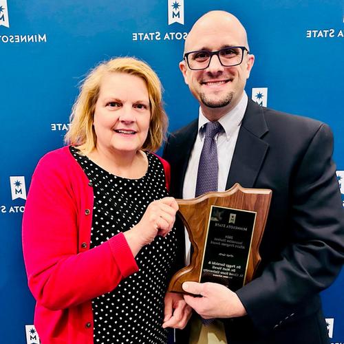 Matt Vorell and Peggy Sarnicki hold an award for HuskiesAdvance